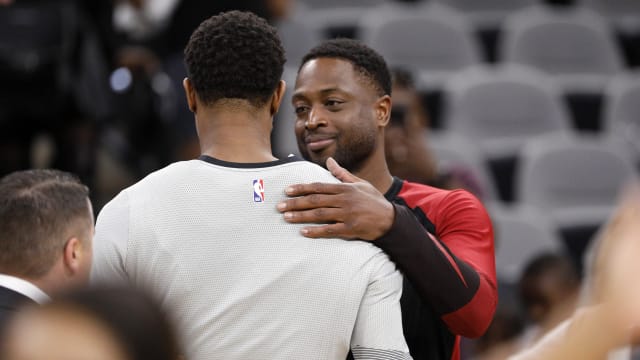 Miami Heat shooting guard Dwyane Wade (behind) hugs San Antonio Spurs shooting guard DeMar DeRozan (front)